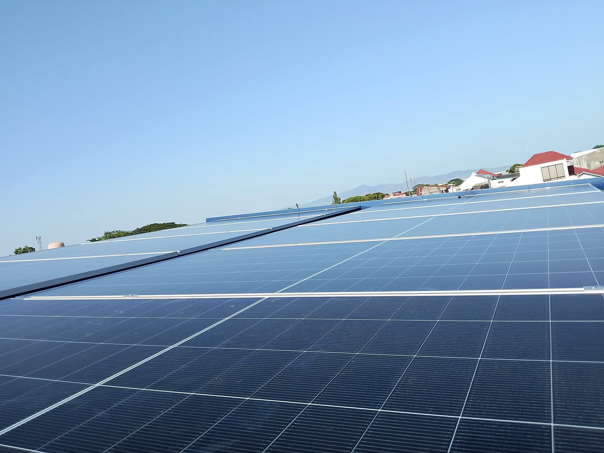 Rows of solar panels on a large rooftop installation